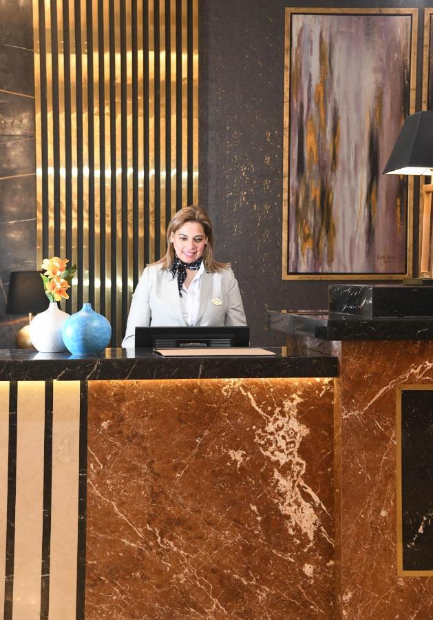 Tolip Gardens Hotel Kairo Exterior foto A hotel receptionist at the front desk
